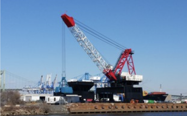 A crane loading logs onto a self-dumping log barge with ThorPlas-Blue bearings.